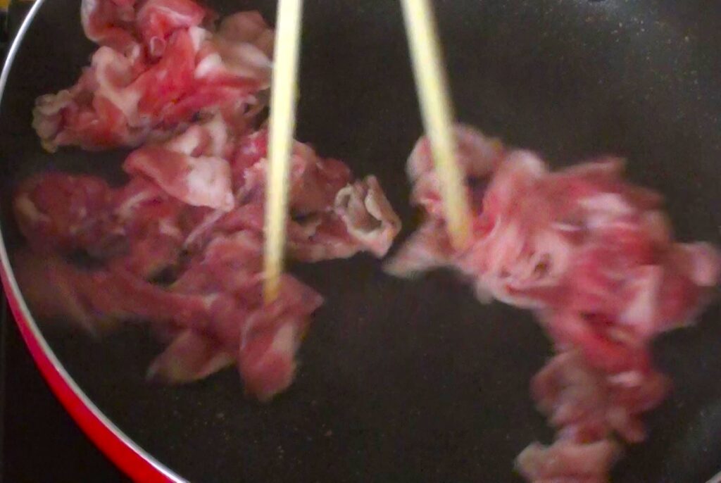 フライパンに豚肉を入れる